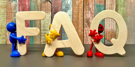 Photo: Beige bold letters F, A and Q are held by small figurines in blue, yellow and red 