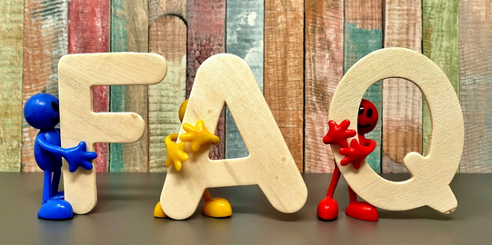 Photo: Beige bold letters F, A and Q are held by small figurines in blue, yellow and red 