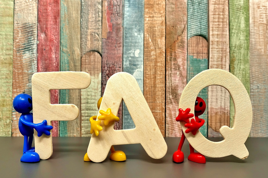 Photo: Beige bold letters F, A and Q are held by small figurines in blue, yellow and red