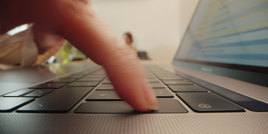 Photo: Close-up of an index finger pushing the "Enter" key on a laptop keyboard