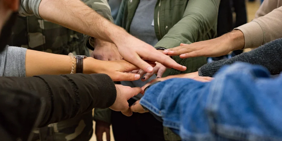 Photo: Hands of various skin colours meet in the middle
